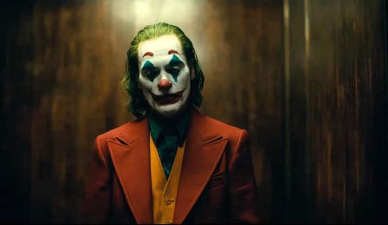 In metro vestito da Joker con una pistola giocattolo