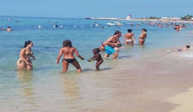 La figlia dell’ambulante gioca in spiaggia con le altre mamme