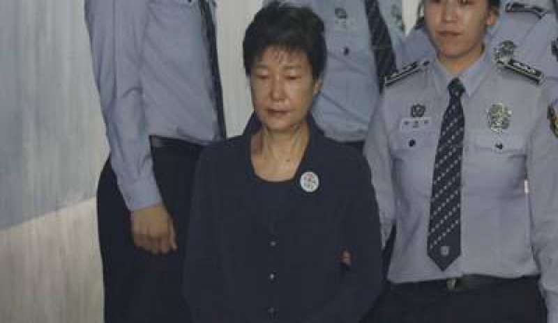 Tuta blu, badge con il numero da prigioniera e manette: in Corea del Sud inizia il processo all’ex presidente Park