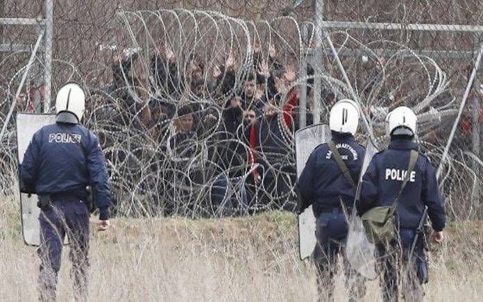Migranti dal lato turco e polizia greca al confine